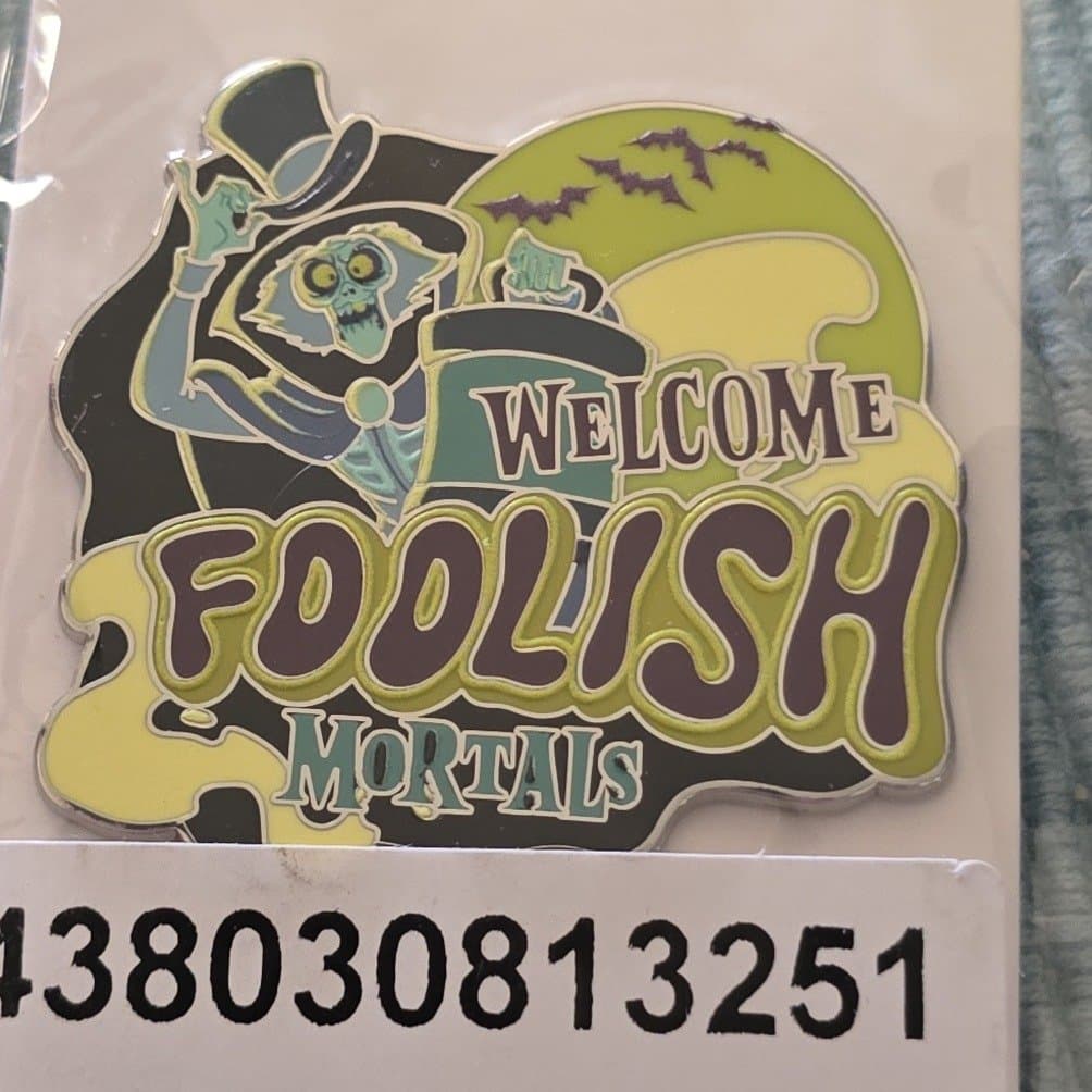 The Hatbox Ghost Welcome Foolish Mortals Glow-in-the-Dark Pin – The Haunted Mansion front