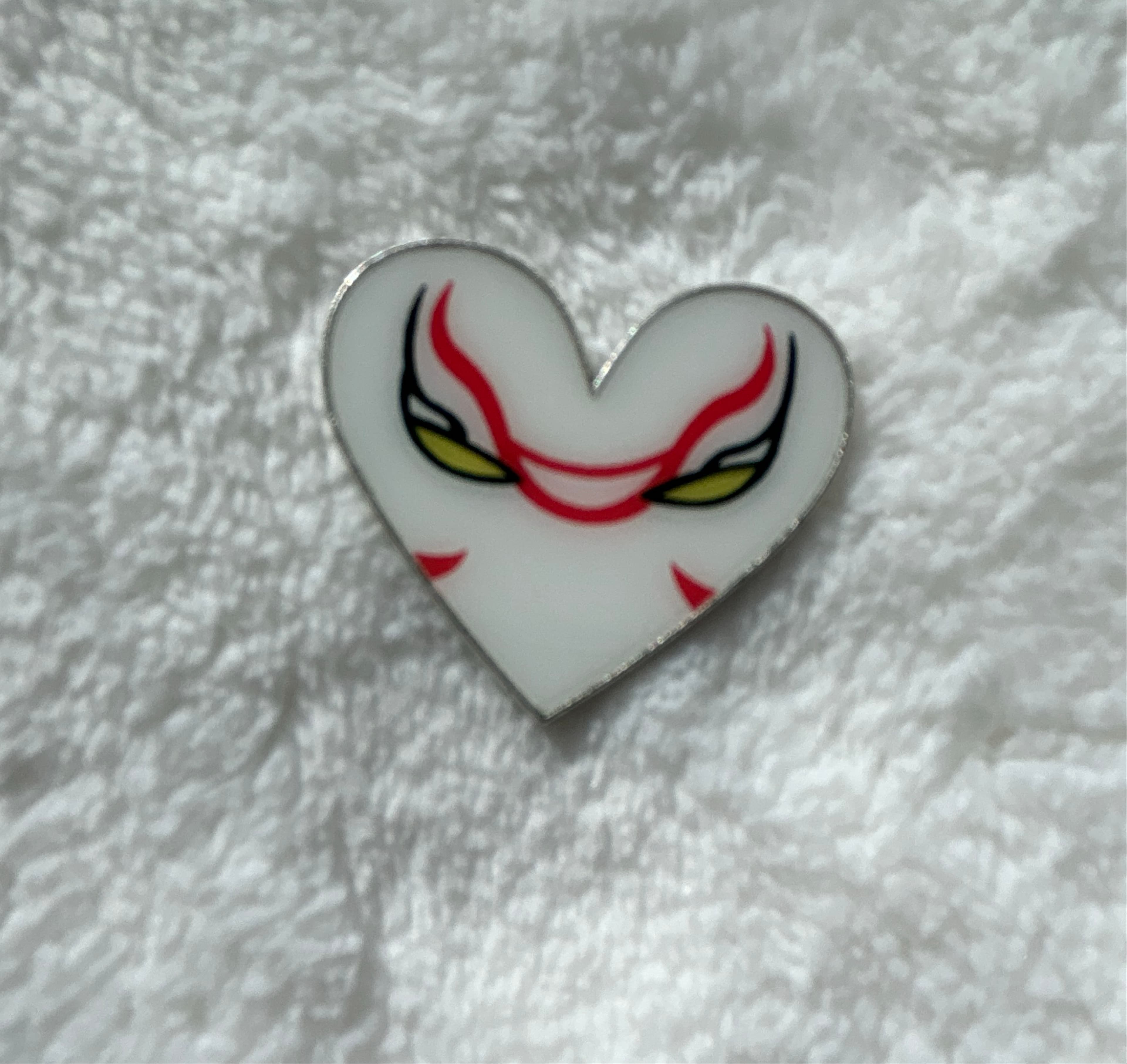 Stylized Mask Face Heart Pin - White with Red Markings and Yellow Eyes front