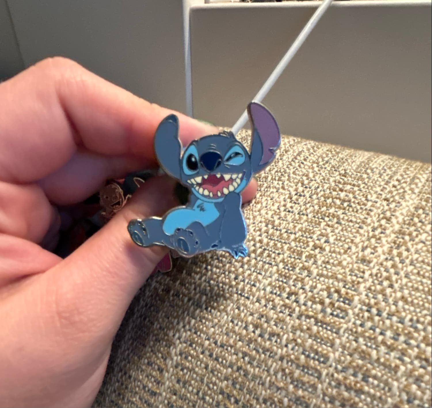 Stitch Sitting, Smiling, and Winking Lanyard Pin front